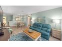 Cozy living room with a teal sofa, wood-look floors, and bright natural light at 9333 Sw 97Th Pl # C, Ocala, FL 34481