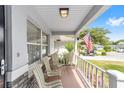 Inviting front porch features striped chairs and an American flag at 9333 Sw 97Th Pl # C, Ocala, FL 34481