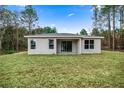 A spacious backyard featuring lush grass, a covered patio, and ample space for outdoor entertaining at 15769 Sw 37Th Cir, Ocala, FL 34473