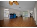 Large living area with laminate flooring, a ceiling fan, and sliding doors to screened porch at 21168 Sw Peach Blossom St, Dunnellon, FL 34431