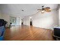 Spacious living room featuring laminate flooring, ceiling fan, and sliding glass doors to the outside at 21168 Sw Peach Blossom St, Dunnellon, FL 34431