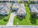 Aerial view of a well-maintained home featuring a lush green lawn, meticulous landscaping, and a concrete driveway at 2323 Nw 55Th Avenue Rd, Ocala, FL 34482