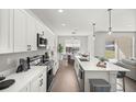 Modern kitchen featuring white cabinets, stainless steel appliances, and a bright dining area at 2647 Sw 178 St, Ocala, FL 34473