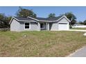 Charming single-story home features a gray exterior, white trim, and a spacious two-car garage at 28 Olive Dr, Ocala, FL 34472