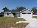 Charming single-story home features a gray exterior, white trim, and a spacious two-car garage at 28 Olive Dr, Ocala, FL 34472