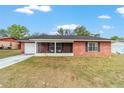 Well-maintained brick home featuring a screened porch and manicured front lawn at 31 Palm Rd, Ocala, FL 34472