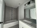 Modern bathroom featuring a tub with tiled walls, granite countertop, and a stylish vanity at 4162 Sw Gardenia Ct, Dunnellon, FL 34431