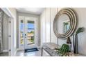 Inviting entryway with stylish console table, decorative mirror, and a glass-paneled front door that fills the area with light at 4180 Sw 53Rd Lane Rd, Ocala, FL 34474