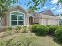 Landscaped front yard featuring a well-maintained lawn and lush green bushes at 779 Oldsmar Ter, The Villages, FL 32163