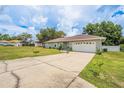 Charming home exterior with a spacious driveway and well-manicured lawn, perfect for outdoor activities at 9 Fir Trail Pass, Ocala, FL 34472