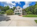 Exterior view of home with three-car garage, driveway, and mature landscaping at 950 Sw 43Rd Pl, Ocala, FL 34471