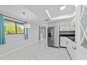 Bright kitchen and dining area featuring modern stainless steel appliances, white cabinets, and marble floors at 10197 Sw 88Th Ter, Ocala, FL 34481