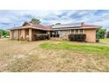 Charming home featuring stone detailing, manicured bushes, and a welcoming front lawn at 10631 W Highway 40, Ocala, FL 34482