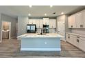Open-concept kitchen with a large center island, white cabinets, and stainless steel appliances at 13081 Sw 78Th Cir, Ocala, FL 34473