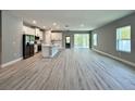 Bright, open-concept living area featuring modern finishes, wood-look floors, and lots of natural light at 13081 Sw 78Th Cir, Ocala, FL 34473