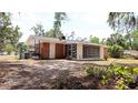 Exterior back view of the home with an enclosed porch and large yard at 1335 Ne 10Th St, Ocala, FL 34470