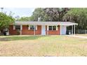 Charming brick home with covered front porch, carport, and large front yard at 1335 Ne 10Th St, Ocala, FL 34470