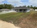 Charming single-story home featuring a manicured lawn, attached garage, and inviting front entrance at 14437 Sw 21St Pl, Ocala, FL 34481