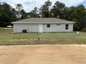 Exterior of home with lush green backyard, irrigation, and a white door at 21 Pl # 14443, Ocala, FL 34481