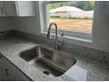 Kitchen sink and countertop with stainless steel faucet fixture and a view of the backyard at 2871 Se 145 Pl, Summerfield, FL 34491