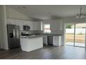 Modern kitchen with white cabinets, stainless steel appliances, an island, and sliding glass doors at 2871 Se 145 Pl, Summerfield, FL 34491
