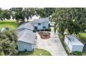 Aerial view of a charming home featuring a spacious driveway, lush landscaping, and a serene lakeside setting at 4237 Chambers St, Lake Wales, FL 33898