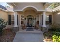 Inviting front entryway featuring rocking chairs and a decorative glass door at 5425 Se 44Th Cir, Ocala, FL 34480
