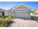 A well maintained home features an attached two-car garage and brick paver driveway at 5430 Nw 46Th Lane Rd, Ocala, FL 34482