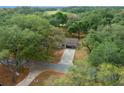 Scenic aerial view of a home nestled among lush trees with a long driveway and a glimpse of a playground at 660 Silver Pass, Ocala, FL 34472