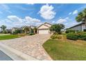 Paver driveway leads to a well-maintained home with lush landscaping at 7455 Sw 97Th Terrace Rd, Ocala, FL 34481