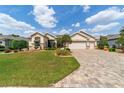 Beautifully landscaped front yard with manicured bushes and brick driveway at 7455 Sw 97Th Terrace Rd, Ocala, FL 34481