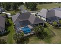 Aerial view of the screened-in pool area with a hot tub and palm trees, adjacent to other homes at 7585 Nw 33Rd Pl, Ocala, FL 34482