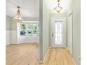Inviting foyer view showing wood floors, chandelier and large bay window perfect for natural light at 8 Banyan Dr, Ocala, FL 34472