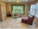 Cozy living room features a floral sofa, glass coffee table, and ample natural light at 9019 Se 120Th Loop, Summerfield, FL 34491