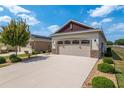 Two car garage with desert landscaping and a long driveway at 9923 Sw 98Th Ln, Ocala, FL 34481