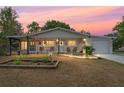 Charming single-story home at sunset with a covered front porch and attached garage at 9940 Sw 103Rd Pl, Ocala, FL 34481