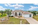 Inviting single-story home features a neutral color palette, arched windows, and a well-manicured lawn under a bright sky at 5245 Nw 21St Loop, Ocala, FL 34482
