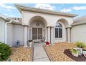 Welcoming front porch with arched entrance, decorative plants, and stone accents leading to the front door at 5245 Nw 21St Loop, Ocala, FL 34482