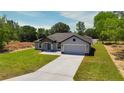 Aerial view of a single-story home with a two-car garage and a long driveway, set on a spacious, green lot at 112 Juniper Run, Ocala, FL 34472