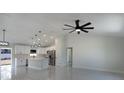 Bright, open-concept living space featuring high ceilings, modern lighting, and seamless flow to the kitchen at 112 Juniper Run, Ocala, FL 34472