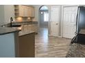 Open kitchen with stainless steel appliances, granite countertops, wood cabinets and wood-look flooring at 11411 Sw 138Th Ln, Dunnellon, FL 34432