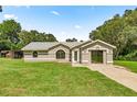 Inviting single-story home with landscaped lawn, garage, and charming architectural details at 14171 Sw 8Th Ave, Ocala, FL 34473