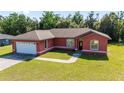 Inviting single-Gathering home featuring a well-manicured lawn and an attached two-car garage at 15087 Sw 43Rd Ct, Ocala, FL 34473