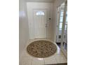 Warm foyer featuring tile flooring and a decorative round rug, leading to a room through glass French doors at 15266 Sw 44Th Ter, Ocala, FL 34473