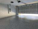The home's garage has an epoxy floor and an automatic door with plenty of overhead lighting at 19660 Sw 59Th Ln, Dunnellon, FL 34431