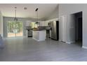 Open-concept kitchen featuring a central island, modern appliances, and light gray tile flooring at 19660 Sw 59Th Ln, Dunnellon, FL 34431