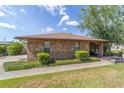 A brick house features a well-kept lawn and mature trees with an inviting sidewalk that leads to the front door at 2045 Se 32Nd St, Ocala, FL 34471