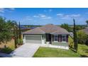 Inviting one-story home showcasing a green lawn, two-car garage, and meticulously maintained landscape at 4013 Ruby Run, Haines City, FL 33844