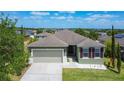 Attractive exterior view of home with a neatly kept lawn, beautiful landscaping, and attached garage at 4013 Ruby Run, Haines City, FL 33844