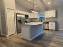 Bright kitchen features stainless appliances, a center island, gray cabinets and granite countertops at 4424 Sw Viola Ct, Dunnellon, FL 34431